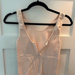Light pink ribbed tank top with eye hook closures. Size XS.